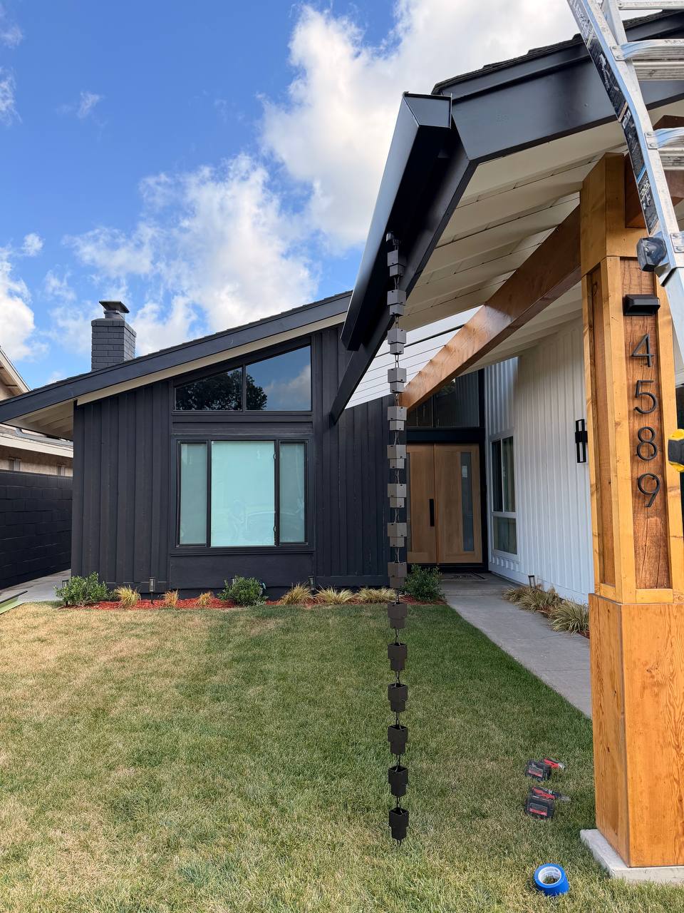 Signature BelFour project: modern black California home with custom black seamless gutters and decorative rain chain at 4589